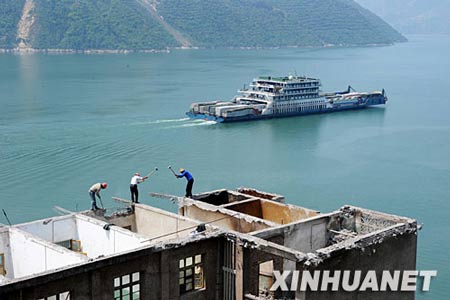 资料图片:4月16日,工人正在拆除湖北省秭归县归州老镇的一幢楼房.