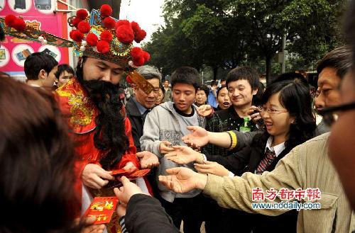 政府人员穿财神服发安全套引女生争抢(图)