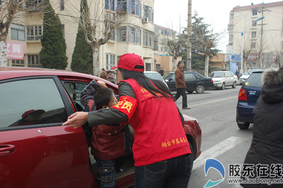 东山街道民生社区义工护送孩子过马路(图) 胶东