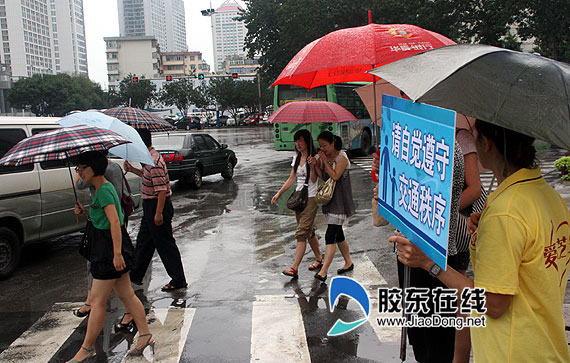 烟台五百义工当 交警 冒雨上街维持交通秩序 日