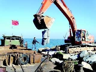 石块礁,管状礁在码头装船运往海上.资料片