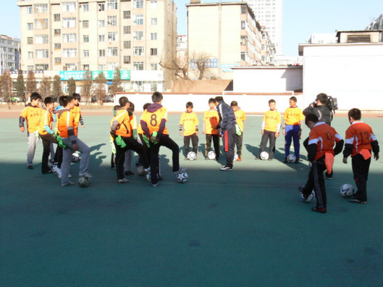 组图:足球讲师助延吉公园小学向同学传球技体