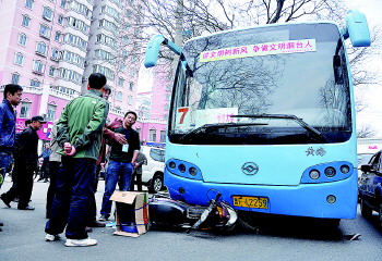 摩托车卷进7路公交车底,真险!