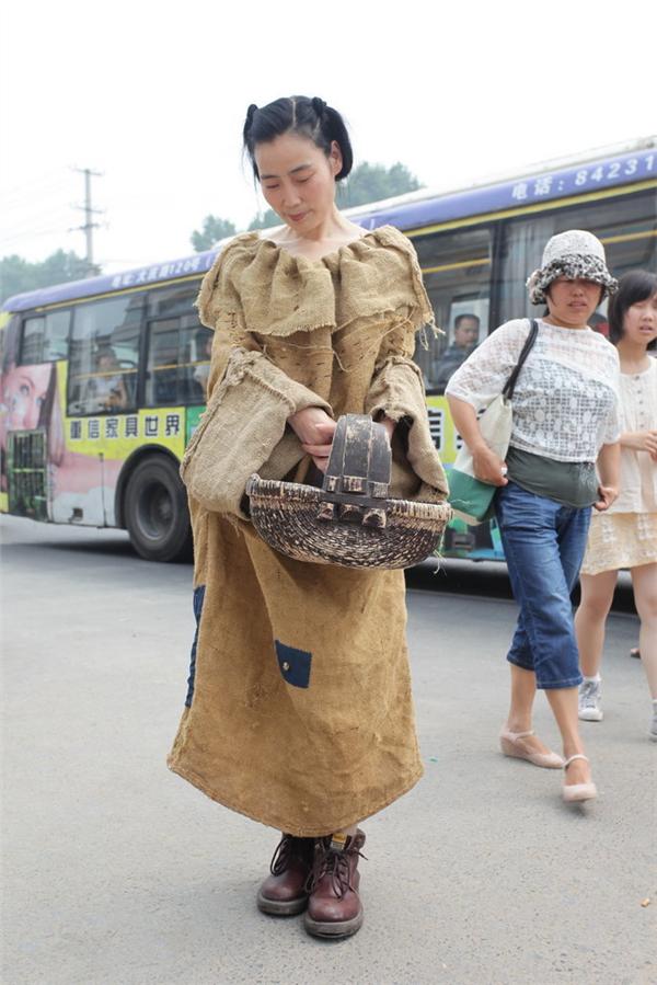 女子身着麻袋服装走在街头.