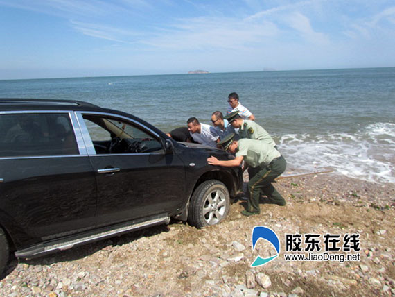 警民合力帮助车主把车推出海滩