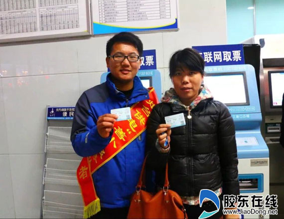 甘宜强(左)在烟台火车站帮忙订票