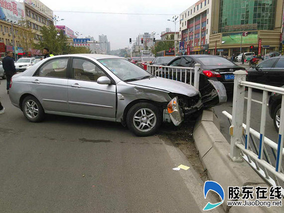 轿车调头与直行车互不相让 两车碰撞护栏被撞
