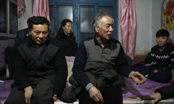 图为当事的《财经》记者高胜科的舅舅鄂力华(右)在向记者介绍情况(2月