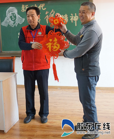 报告会结束后,郭丕义将义工们亲手编织的中国结送到教师代表手中