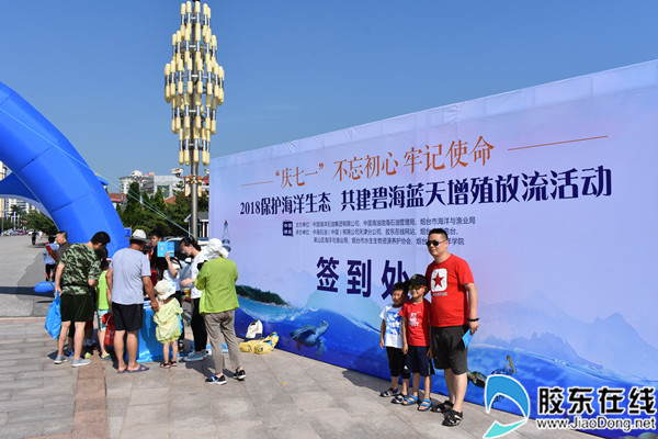 市民带孩子在活动背景板前合影
