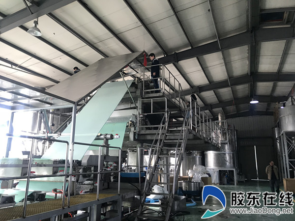 方琼谊在车间和工人一起调试设备