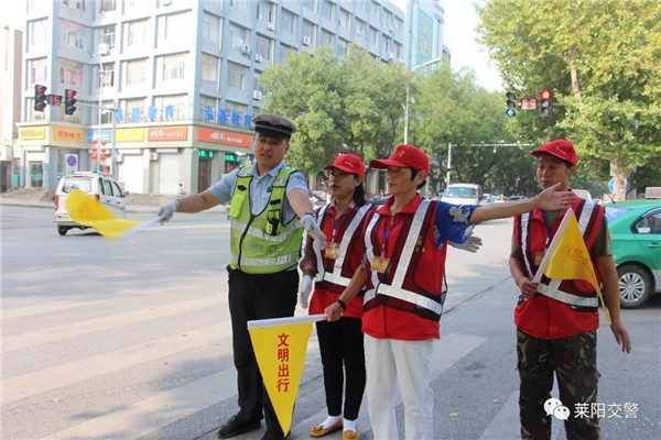 [莱阳交警组织志愿者开展文明交通劝导服务活动]志愿者劝导行人