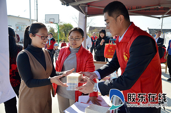 烟台农商银行牟平支行服务志愿者为村民发放奖品