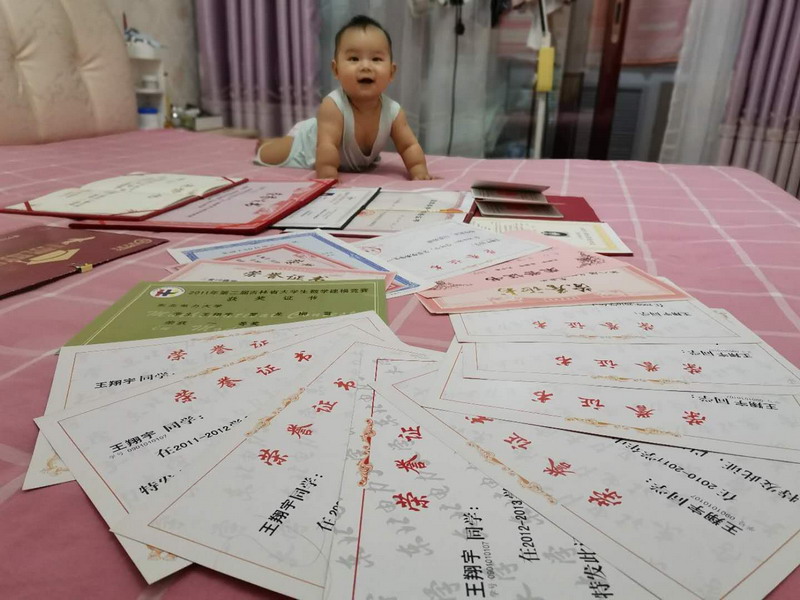 栖霞供电王翔宇新生儿宝宝的在她布满证书的床上。任梦雪摄
