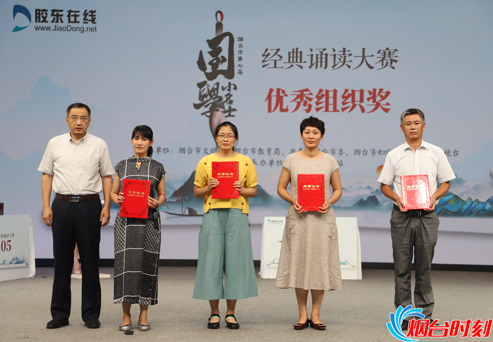 烟台市文明办副主任吕忠民(左一)为优秀组织单位颁奖