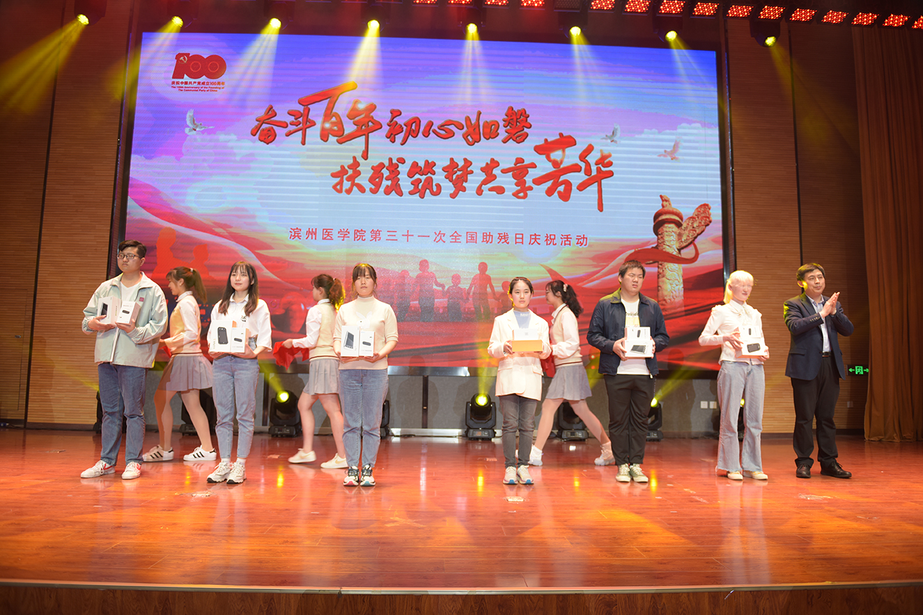 3张玉龙为学生颁发辅助器具作为节日礼物