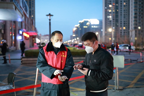 图为志愿者张传钦(左一)参加疫情防控工作