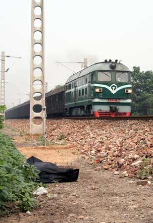 男子的身体被火车甩出后翻滚出20余米,头朝东摔在两条铁轨之间