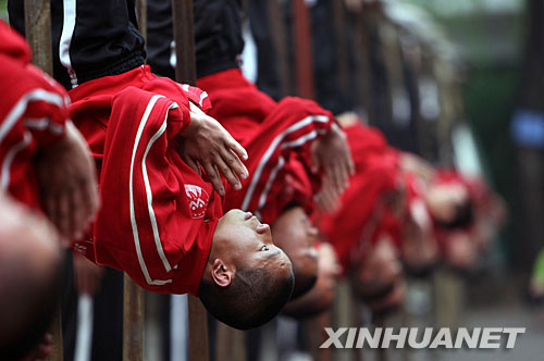 图为武校学员在进行"杠上倒挂"的基本功训练.