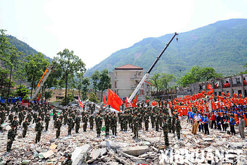 在北川中學救援現場,搜救人員向汶川大地震遇難者默哀