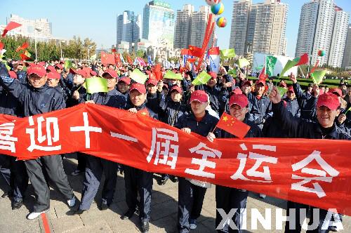 11月8日,参加健步走活动的市民打出"喜迎第十一届全运会"的横幅.