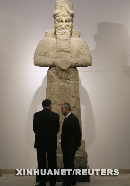 两名参观者在一座亚述时期的雕像前交谈