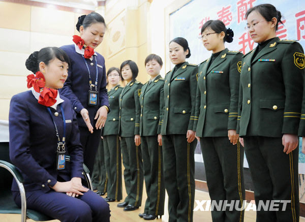 3月4日,石家庄边防检查站的女警官在向空姐学习坐姿.