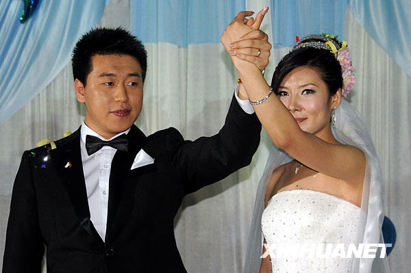 11月29日,新人庞伟(左)和杜丽在婚礼上携手向来宾致意.