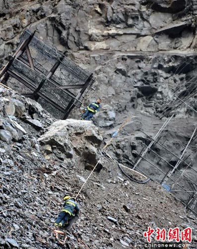 图为消防官兵正在山崖上救人.中新社发 肖波 摄