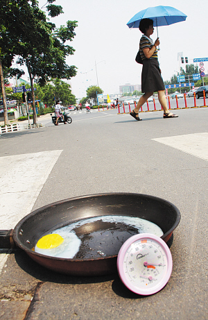 记者将鸡蛋打入铁锅中,放在马路地面上,到13时44分左右,鸡蛋竟然快煎