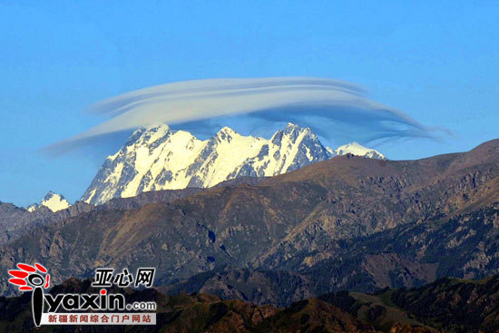 新疆天山山脉最高峰博格达峰上空出现一团云彩,像一顶帽子