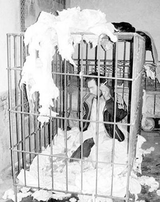图为一精神病患者被囚禁在铁笼中(资料图片)