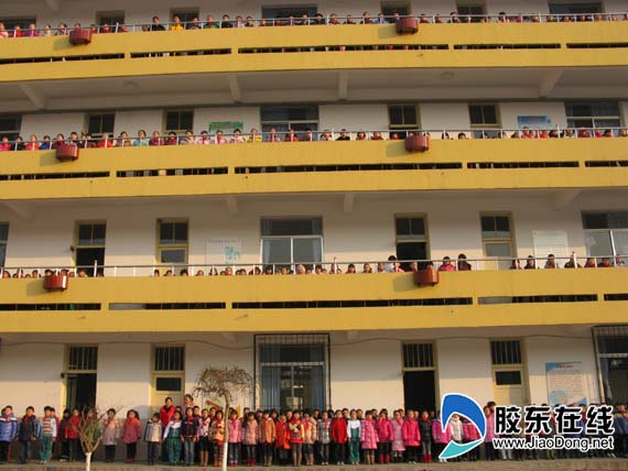 因为天气寒冷,葡萄山小学800多学生在教学楼里迎接升旗仪式