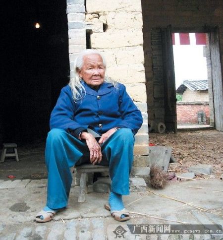 26日上午,"死而复生"的黎秀芬老人默默地坐在家门口.记者 赵敏摄