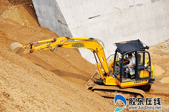 挖掘机在桥下整修边坡