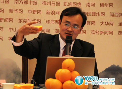 平远县委书记曾尚忠讲解平远慈橙独特切法.梅州网陈炯峰摄.