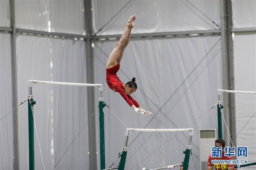 中国体操队选手范忆琳在教练王群策指导下训练高低杠