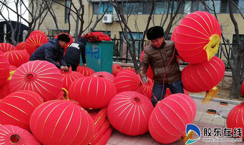 景观施工人员在莱山区宝源路安装大红灯笼
