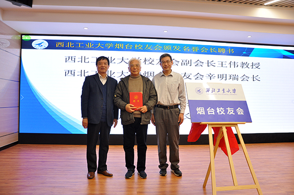 聘书,张英群向烟台校友会副会长兼秘书长郭金刚赠送烟台校友会会旗